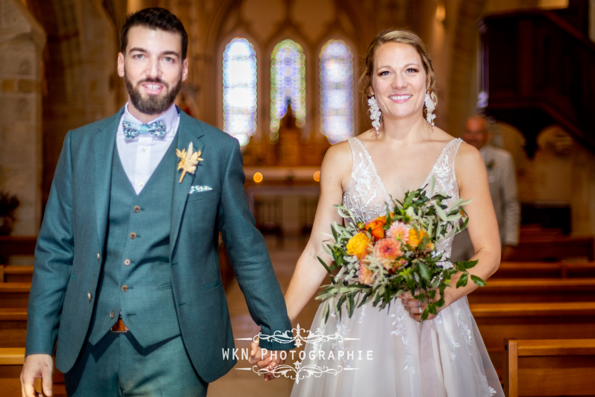 Claire et Corentin sortent de l'église en tant que mari et femme, rayonnants de bonheur et entourés de leurs proches.